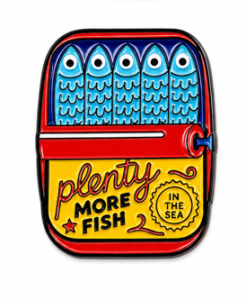 Kolorowy pin z emalią przedstawiający sardynki w dekoracyjnej puszce w stylu retro