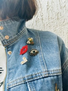 Broszka, oko z kamieniami na kurtce jeansowej sogold